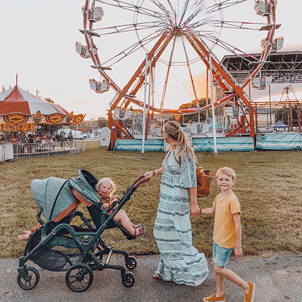 Mom strolling with kids in the Curve stroller