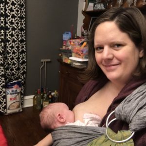 Mom breastfeeding baby in a sling carrier
