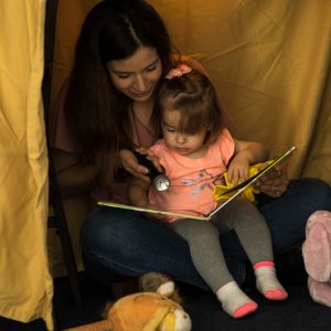 Mom reading book with baby girl