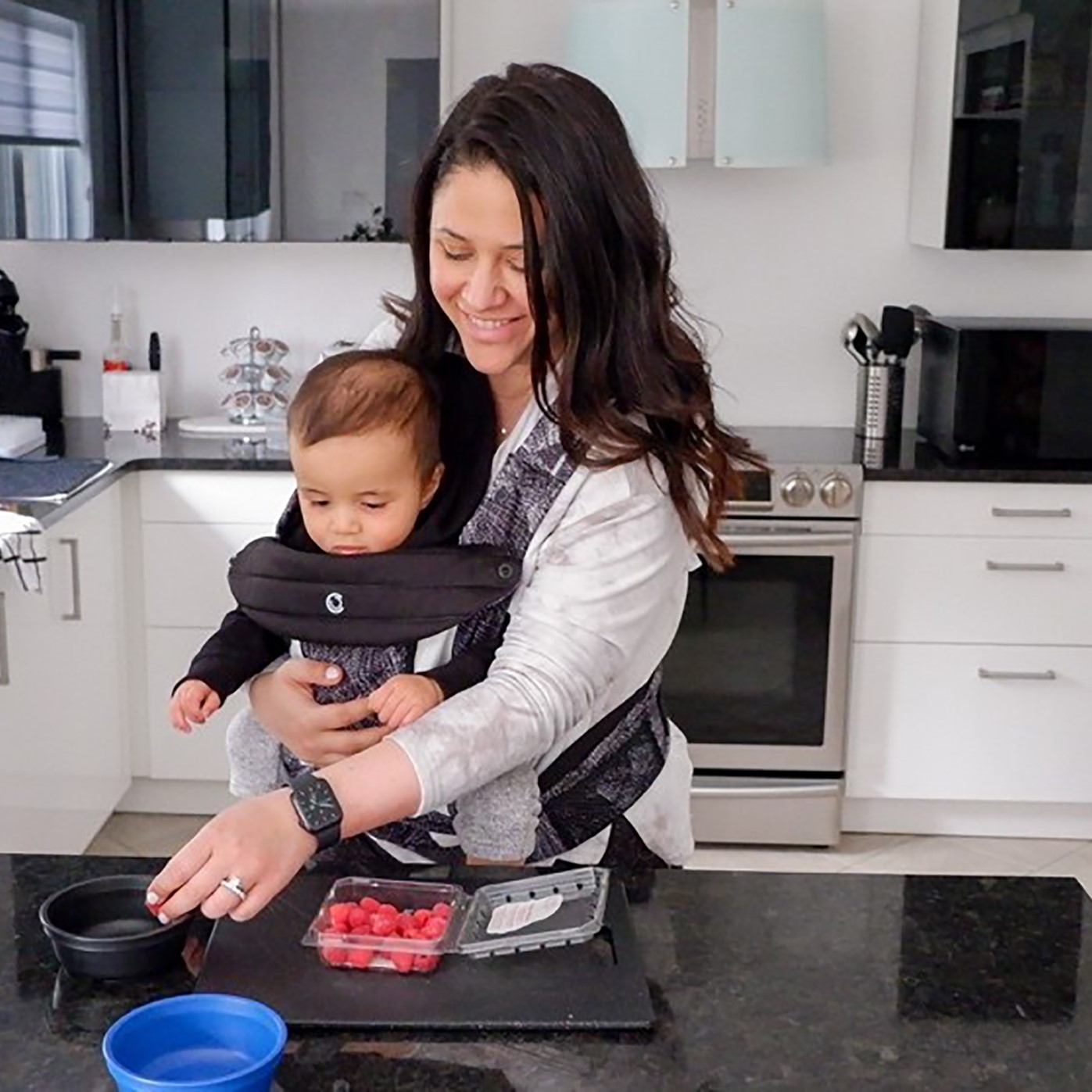 Mom in the kitchen wearing baby in the Cocoon carrier