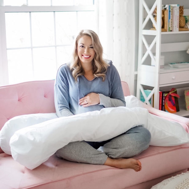 Mom-to-be sitting with the Contours pregnancy pillow