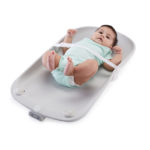 baby lying on back on changing pad